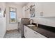 Well-lit laundry room with patterned tile flooring, white cabinets, and modern washer and dryer at 5623 Raintree Dr, Parker, CO 80134