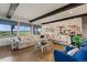 Open-concept living room with exposed beams, hardwood floors, and plenty of natural light at 5623 Raintree Dr, Parker, CO 80134