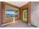 A balcony with wood-paneled walls, a large window, and a door to access the outside, featuring tiled flooring at 4258 Tennyson St # 104, Denver, CO 80212