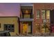 Modern brick exterior with a balcony and street-level storefront or entrance at dusk at 4258 Tennyson St # 104, Denver, CO 80212
