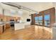 Bright, open living space with wood floors, exposed ductwork, brick accent wall, and modern kitchen at 4258 Tennyson St # 104, Denver, CO 80212