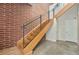 Modern staircase with brick wall, wood stairs, and metal railing at 4258 Tennyson St # 104, Denver, CO 80212