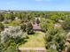 Aerial view showcasing the backyard, patio, mature trees, and neighboring rooftops at 2502 S Lima St, Aurora, CO 80014