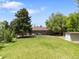 Expansive backyard featuring a large lawn, mature trees, shed, and patio seating area at 2502 S Lima St, Aurora, CO 80014