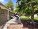 Brick patio with seating area, a beautiful tree, and grassy backyard at 2502 S Lima St, Aurora, CO 80014