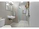 Cozy bathroom featuring a tiled floor, walk-in shower, vanity with sink, and plant decor at 2502 S Lima St, Aurora, CO 80014