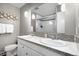 Bright bathroom featuring a double vanity, framed mirror, tiled shower, and modern fixtures at 2502 S Lima St, Aurora, CO 80014