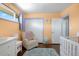 Comfortable bedroom featuring hardwood floors, a cozy chair, and natural light from the window at 2502 S Lima St, Aurora, CO 80014