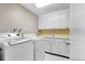 Functional laundry room with washer, dryer, and ample storage at 2502 S Lima St, Aurora, CO 80014