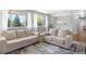 Bright living room featuring neutral furniture, large windows, and hardwood floors with area rug at 2502 S Lima St, Aurora, CO 80014