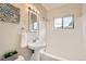 This bathroom features a pedestal sink, tub, and a bright window at 1237 Tamarac St, Denver, CO 80220