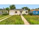 Quaint yellow home with a white garage door and lush green lawn, offering curb appeal and suburban charm at 1237 Tamarac St, Denver, CO 80220