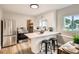 Modern kitchen featuring stainless steel appliances, white cabinets, and a breakfast bar with stool seating at 1237 Tamarac St, Denver, CO 80220