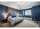 Cozy bedroom featuring a decorative wooden paneled wall, plush carpet, and a ceiling fan at 7050 S Picadilly St, Aurora, CO 80016