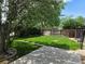 Spacious backyard with a lush lawn, concrete patio, and mature trees at 2285 Ironton St, Aurora, CO 80010