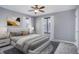 Staged bedroom with neutral walls, carpet, ceiling fan, large windows with curtains, and stylish decor at 2285 Ironton St, Aurora, CO 80010