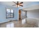 Open living room featuring wood floors, large windows, and a ceiling fan at 2285 Ironton St, Aurora, CO 80010