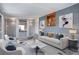 Staged basement living room with gray brick, recessed lights, a bar, and modern decor at 2285 Ironton St, Aurora, CO 80010
