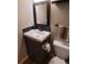 Powder room featuring dark vanity, framed mirror, and chrome hardware at 10806 W Evans Ave # 5, Lakewood, CO 80227
