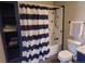 Bathroom features a tub/shower combo, white subway tile, and blue and white striped curtain at 10806 W Evans Ave # 5, Lakewood, CO 80227