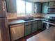 Well-lit kitchen featuring stainless steel appliances, stylish green cabinetry, and modern sink fixtures at 10806 W Evans Ave # 5, Lakewood, CO 80227