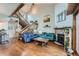 Bright living room with hardwood floors, stone fireplace, and exposed wood beam staircase at 10806 W Evans Ave # 5, Lakewood, CO 80227