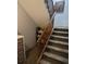 Carpeted Staircase with wooden railing and storage shelves at 10806 W Evans Ave # 5, Lakewood, CO 80227
