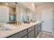 Bright bathroom with double vanity sinks, full mirror and glass enclosed shower at 95 N Vandriver Pl, Aurora, CO 80018