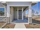 Inviting front porch featuring stone accents, modern lighting and a stylish front door at 95 N Vandriver Pl, Aurora, CO 80018