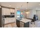Modern kitchen featuring a center island, stainless steel appliances, and stylish pendant lighting at 95 N Vandriver Pl, Aurora, CO 80018