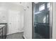 Bathroom with tiled standing shower, dark fixtures and white door to the outside at 4873 Cathay Ct, Denver, CO 80249
