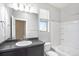 Well-lit bathroom with vanity, large mirror, shower-tub combo, and window at 4873 Cathay Ct, Denver, CO 80249