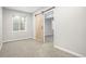 Bedroom with neutral walls and carpet plus a sliding barn door entry and a window allowing natural light in the room at 4873 Cathay Ct, Denver, CO 80249