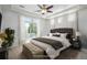 Staged main bedroom featuring a bed, carpet, white trim, windows, and neutral tones at 4873 Cathay Ct, Denver, CO 80249