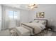 Staged bedroom features large window, neutral paint, carpet, and ceiling fan at 4873 Cathay Ct, Denver, CO 80249