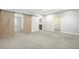 Large bedroom with gray carpet, bright walls, wooden sliding doors, and multiple entryways offer versatility and modern design at 4873 Cathay Ct, Denver, CO 80249
