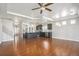 Open living room features wood floors, a kitchen island, stainless appliances and dark cabinetry at 4873 Cathay Ct, Denver, CO 80249