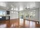 Spacious living room with wood floors and large windows next to the open kitchen at 4873 Cathay Ct, Denver, CO 80249