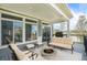 This virtually staged covered patio showcases a cozy fire pit, comfortable seating, and a built-in grill, perfect for outdoor gatherings at 4873 Cathay Ct, Denver, CO 80249