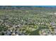 An aerial shot of a community showcases lush landscaping, mature trees, a playground and a tranquil pond at 7506 Chipmunk Pl, Littleton, CO 80125