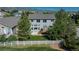 Well-maintained backyard features a patio, deck, lush lawn, and white picket fence at 7506 Chipmunk Pl, Littleton, CO 80125