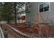 A backyard featuring a playset, wooden deck, and a well-maintained brick flower bed at 7506 Chipmunk Pl, Littleton, CO 80125