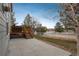 Back patio and wooden deck are features in this grassy backyard with a white fence at 7506 Chipmunk Pl, Littleton, CO 80125