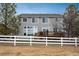 Grassy backyard with a white fence, offering access to the wooden deck and a glimpse of the home at 7506 Chipmunk Pl, Littleton, CO 80125