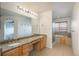 Bathroom featuring a granite countertop, double sinks, jacuzzi tub, and glass enclosed shower at 7506 Chipmunk Pl, Littleton, CO 80125