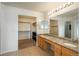 Bathroom with granite countertop, double sinks, large mirror, and walk-in closet at 7506 Chipmunk Pl, Littleton, CO 80125