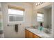 Bathroom featuring a double sink vanity with granite countertop and a mirror with views from the window at 7506 Chipmunk Pl, Littleton, CO 80125