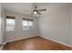 Bedroom with hardwood floors, neutral paint, ceiling fan and two windows provide natural light at 7506 Chipmunk Pl, Littleton, CO 80125
