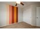 Bedroom featuring carpeted floors, a ceiling fan, and a wall with color panels at 7506 Chipmunk Pl, Littleton, CO 80125