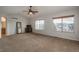 Bright primary bedroom featuring neutral carpeting, natural light, and a ceiling fan at 7506 Chipmunk Pl, Littleton, CO 80125